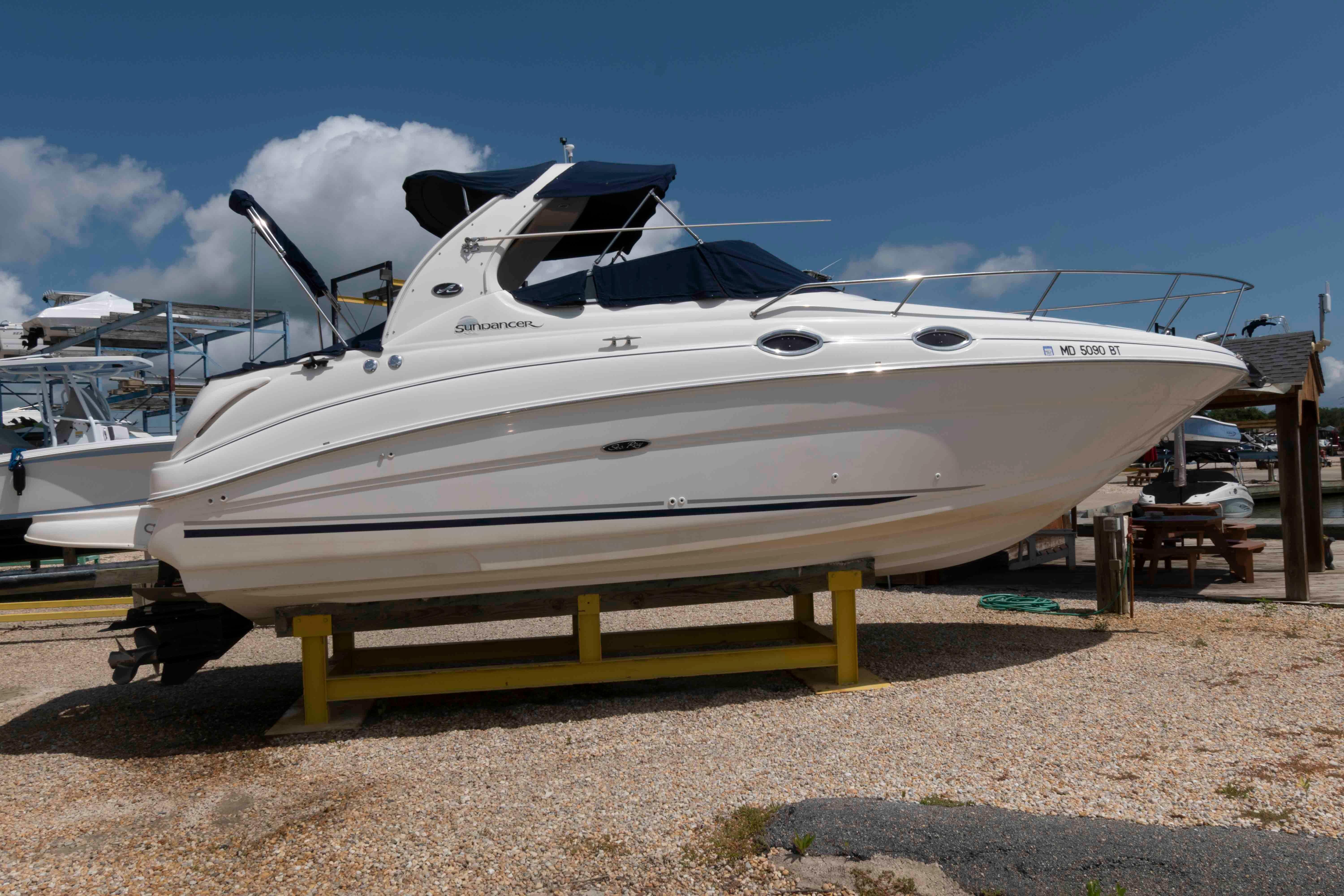 Sea Ray 280 Sundancer 2004 Sea Ray 280 Sundancer boat on dry dock under clear blue sky.