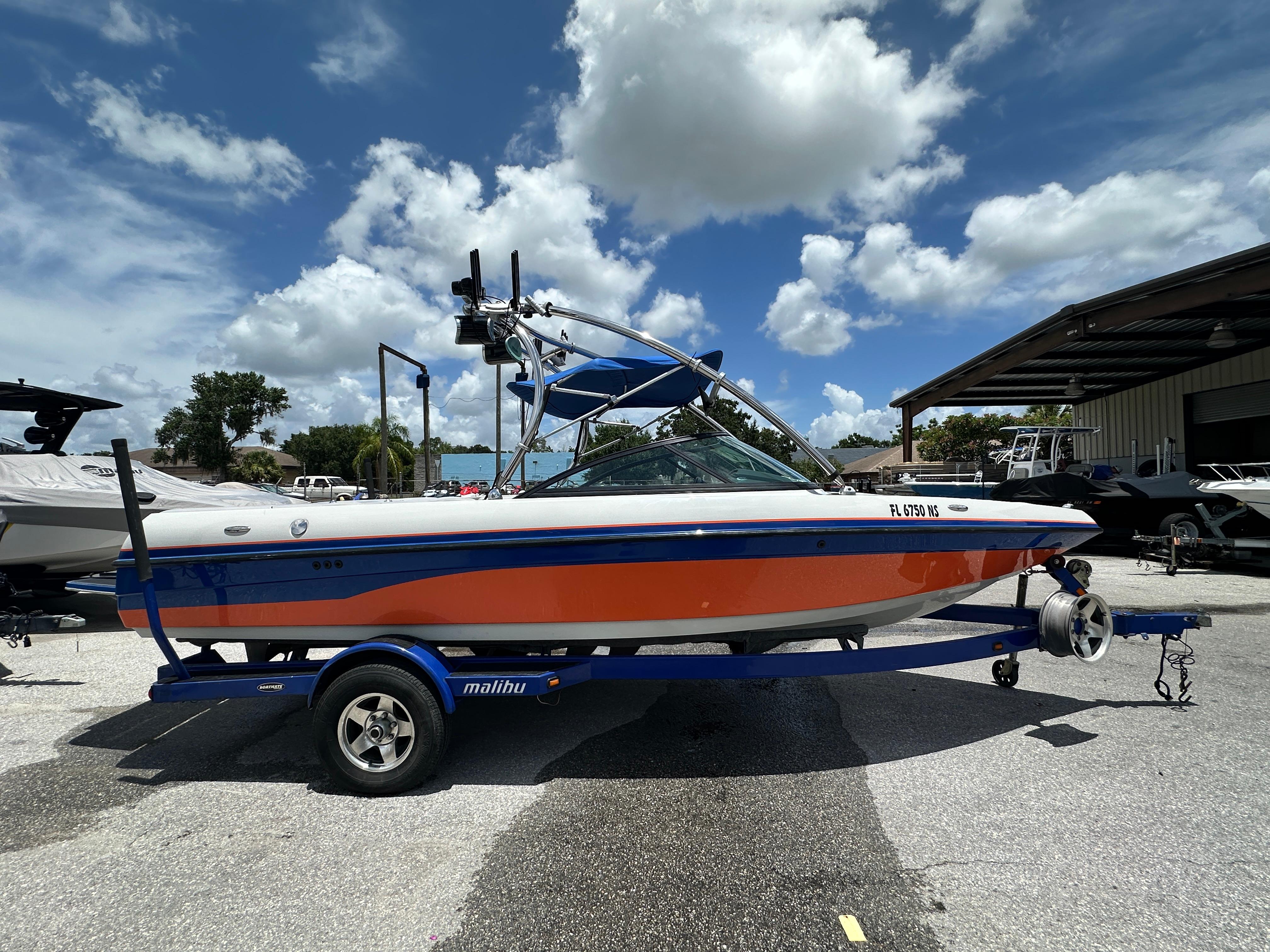Malibu vRide 2008 Malibu vRide boat on trailer under a partly cloudy sky.
