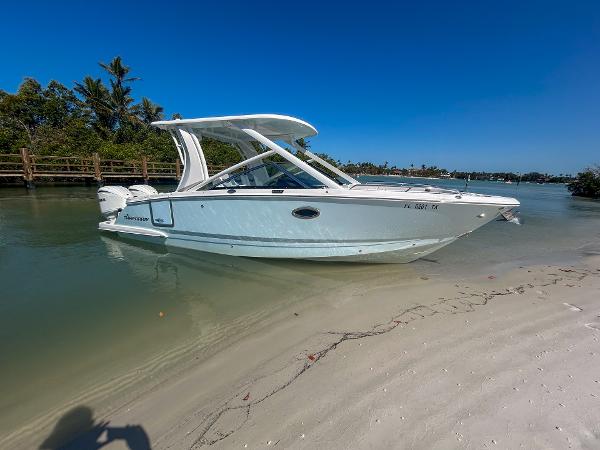 Chaparral 280 OSX 2024 Chaparral 280 OSX boat docked on a sandy beach with clear blue skies.