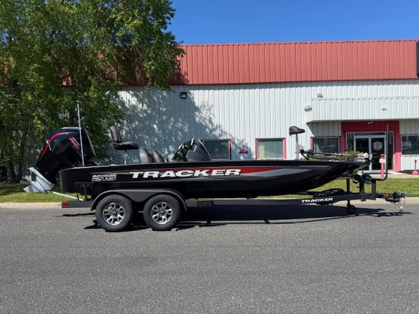 Tracker Savage 215 2025 Tracker Savage 215 boat on trailer, parked outside a building.