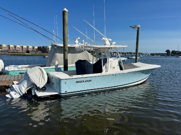 Regulator 28 2018 Regulator 28 boat docked in a marina, clear blue sky.