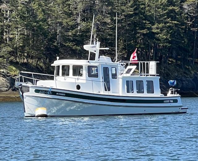 Nordic Tug 32 2007 Nordic Tug 32 boat on water with forested background.