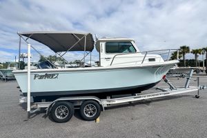 Parker 2120 Sport Cabin 2023 Parker 2120 Sport Cabin boat on trailer, parked outdoors under cloudy sky.