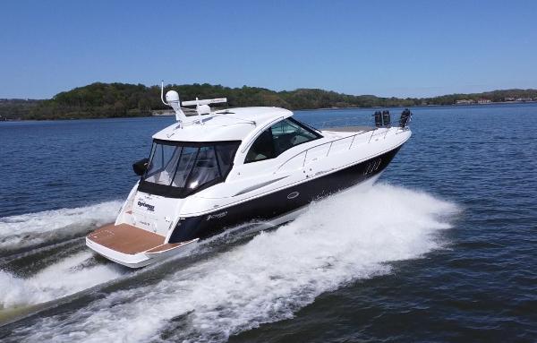 Cruisers Yachts 420 Sports Coupe 2009 Cruisers Yachts 420 Sports Coupe cruising on a serene lake under clear blue skies.