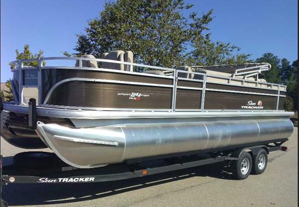 Sun Tracker Sportfish 24 XP3 2025 Sun Tracker Sportfish 24 XP3 pontoon boat on trailer, parked outdoors.