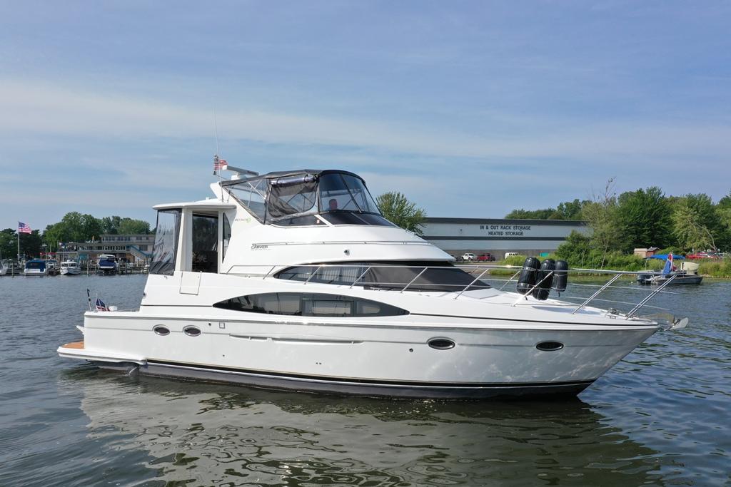 Carver 444 Cockpit Motor Yacht 2003 Carver 444 Cockpit Motor Yacht on calm water, with marina background.