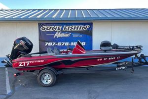 Nitro Z17 2024 Nitro Z17 boat in red, parked on a trailer outside a marine shop.