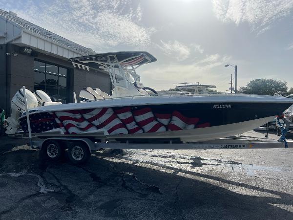 Glasstream 280 Pro-XS 2019 Glasstream 280 Pro-XS boat with American flag design on trailer, parked outdoors.