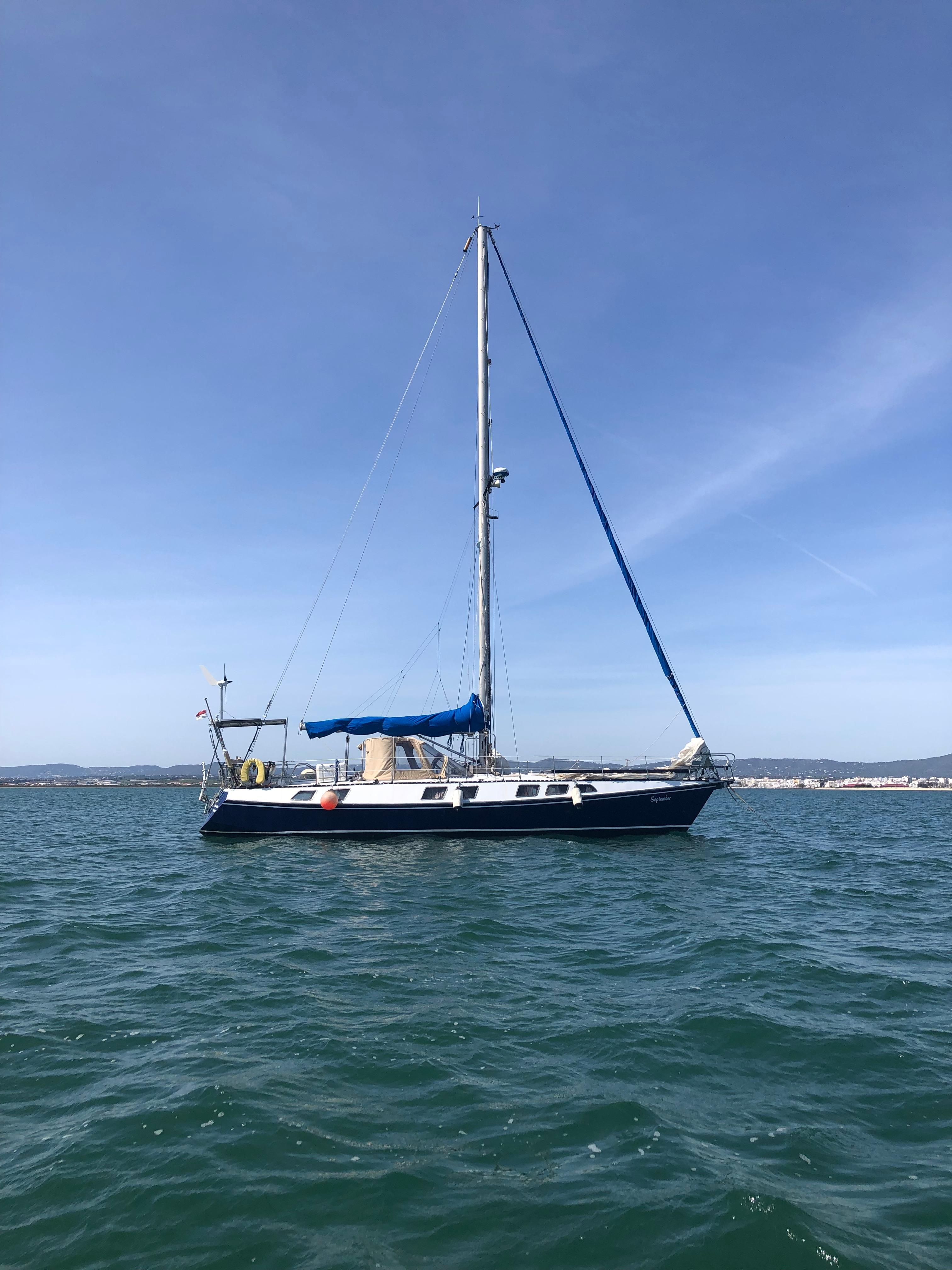 Custom Reinke Hydra SC Sailboat "Reinke Hydra SC" 1984 on calm water under clear blue sky.