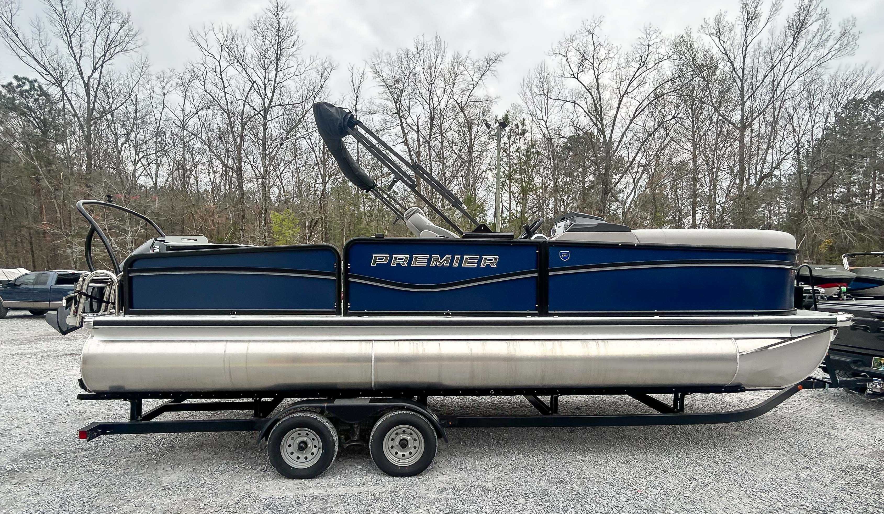 Premier 230 SunSation Angler 2024 Premier 230 SunSation Angler pontoon boat on trailer, parked outdoors.