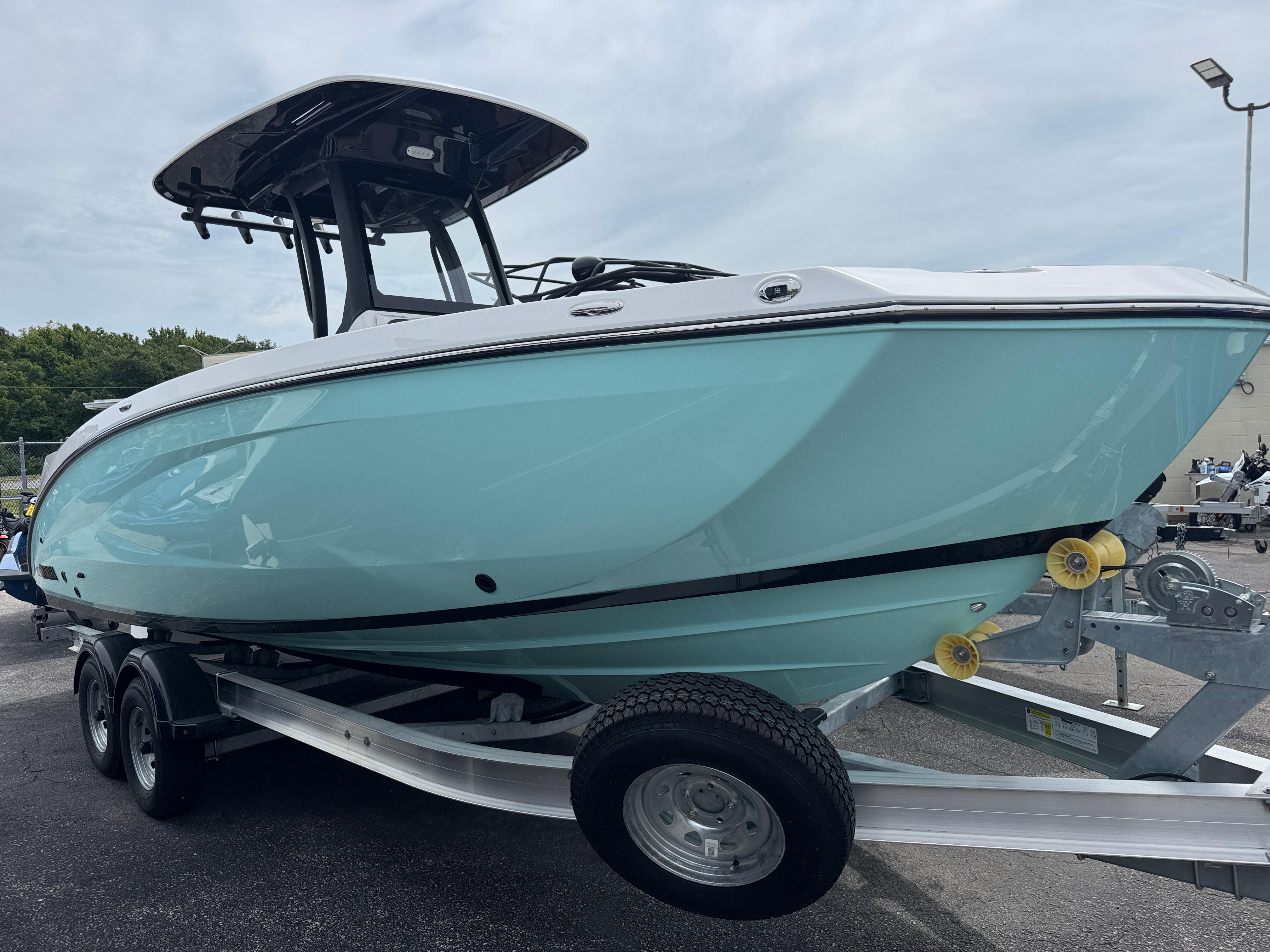 Yamaha Boats 255 FSH Sport H 2025 Yamaha Boats 255 FSH Sport H on trailer, light blue hull, overcast sky.
