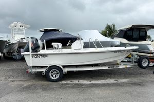 Frontier 180 2024 Frontier 180 boat on trailer, parked outdoors under cloudy sky.