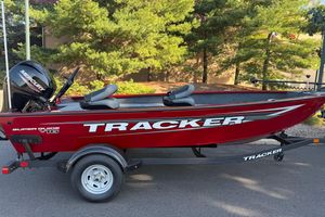 Tracker Super Guide V-16 T 2026 Tracker Super Guide V-16 T boat on trailer, red with Mercury engine, parked outdoors.