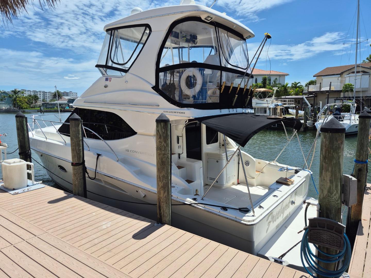 Silverton 38 Convertible 2002 Silverton 38 Convertible yacht docked at marina under clear blue sky.