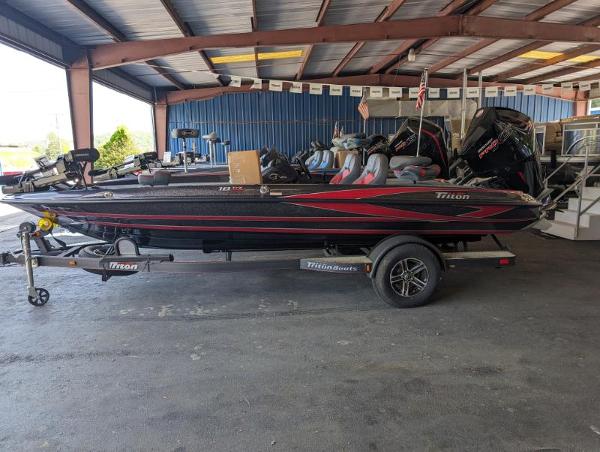Triton 18 TrX 2024 Triton 18 TrX bass boat on trailer in a covered storage area.