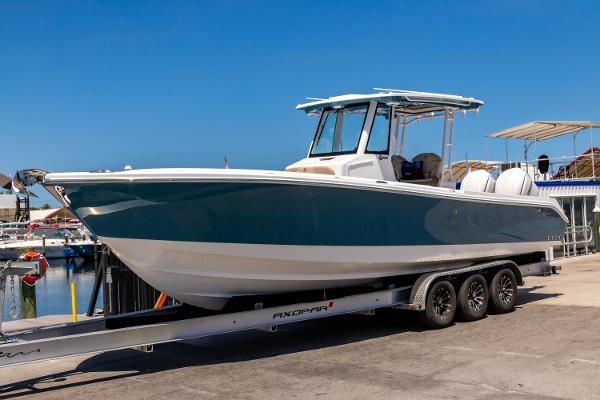 Edgewater 325CC 2025 Edgewater 325CC boat on trailer at marina, clear blue sky background.