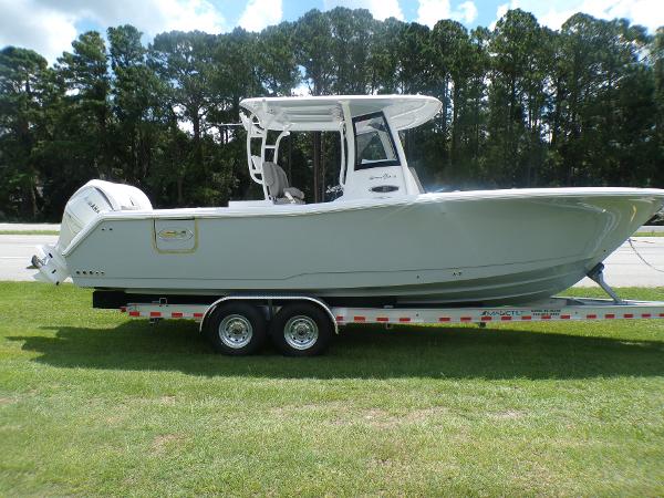 Sea Hunt Gamefish 28 2025 Sea Hunt GAMEFISH 28 on trailer, side view, parked on grass.