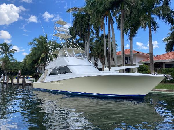 Viking 55 Sport Fish 1999 Viking 55 Sport Fish yacht docked by palm trees under a blue sky.