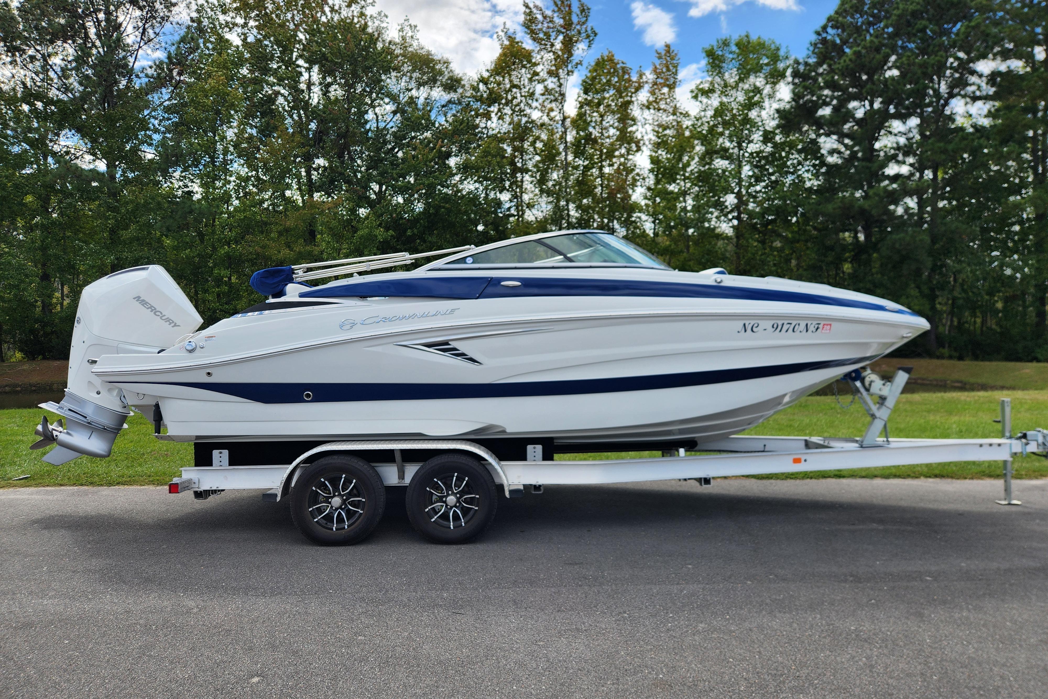 Crownline Eclipse E240 XS 2024 Crownline Eclipse E240 XS boat on trailer, parked outdoors.