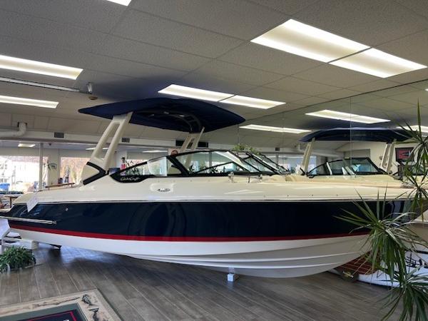 Chris-Craft Sportster 25 2025 Chris-Craft Sportster 25 boat displayed indoors, sleek design with blue and white exterior.