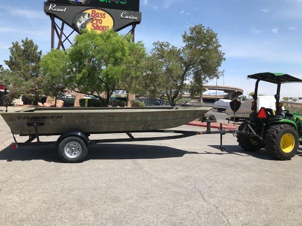 Tracker Grizzly 1754 Jon 2025 Tracker Grizzly 1754 Jon boat on trailer, parked outdoors near trees and a tractor.