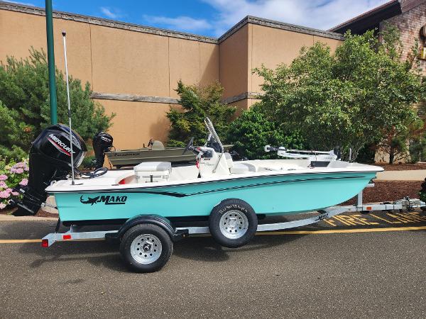 Mako Pro Skiff 15 CC 2024 Mako Pro Skiff 15 CC boat on a trailer, parked outdoors.