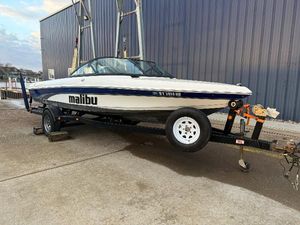 Malibu Response LX 2002 Malibu Response LX boat on trailer, parked outdoors.