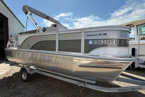 SunCatcher Select 18F 2023 G3 BOATS Select 18f pontoon boat on trailer, parked outside a building.