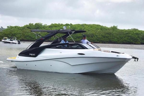 NX Boats 280 Xtreme 2025 NX Boats 280 Xtreme cruising on a calm river with lush greenery.