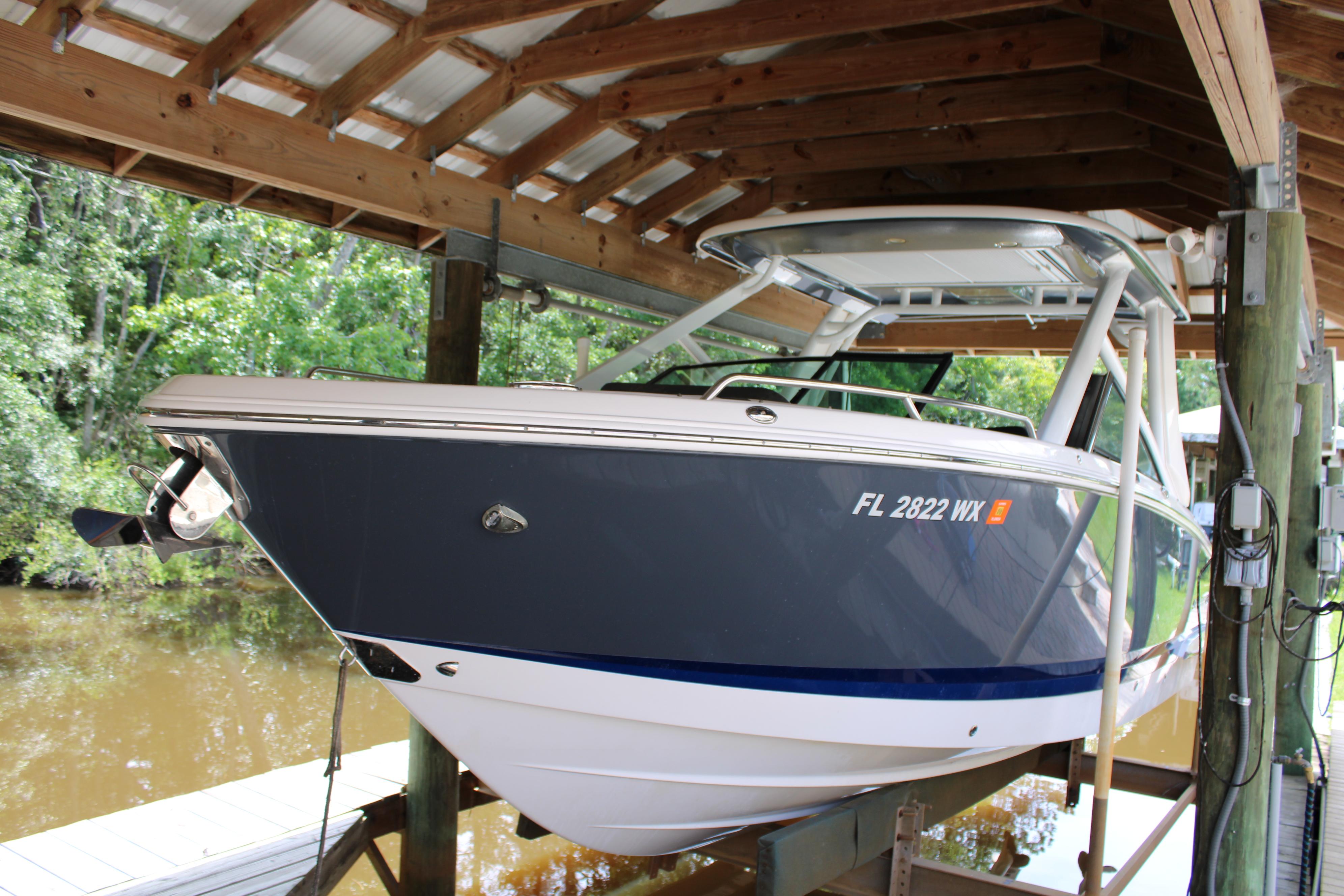 Chaparral 280 OSX 2021 Chaparral 280 OSX boat docked under wooden shelter.