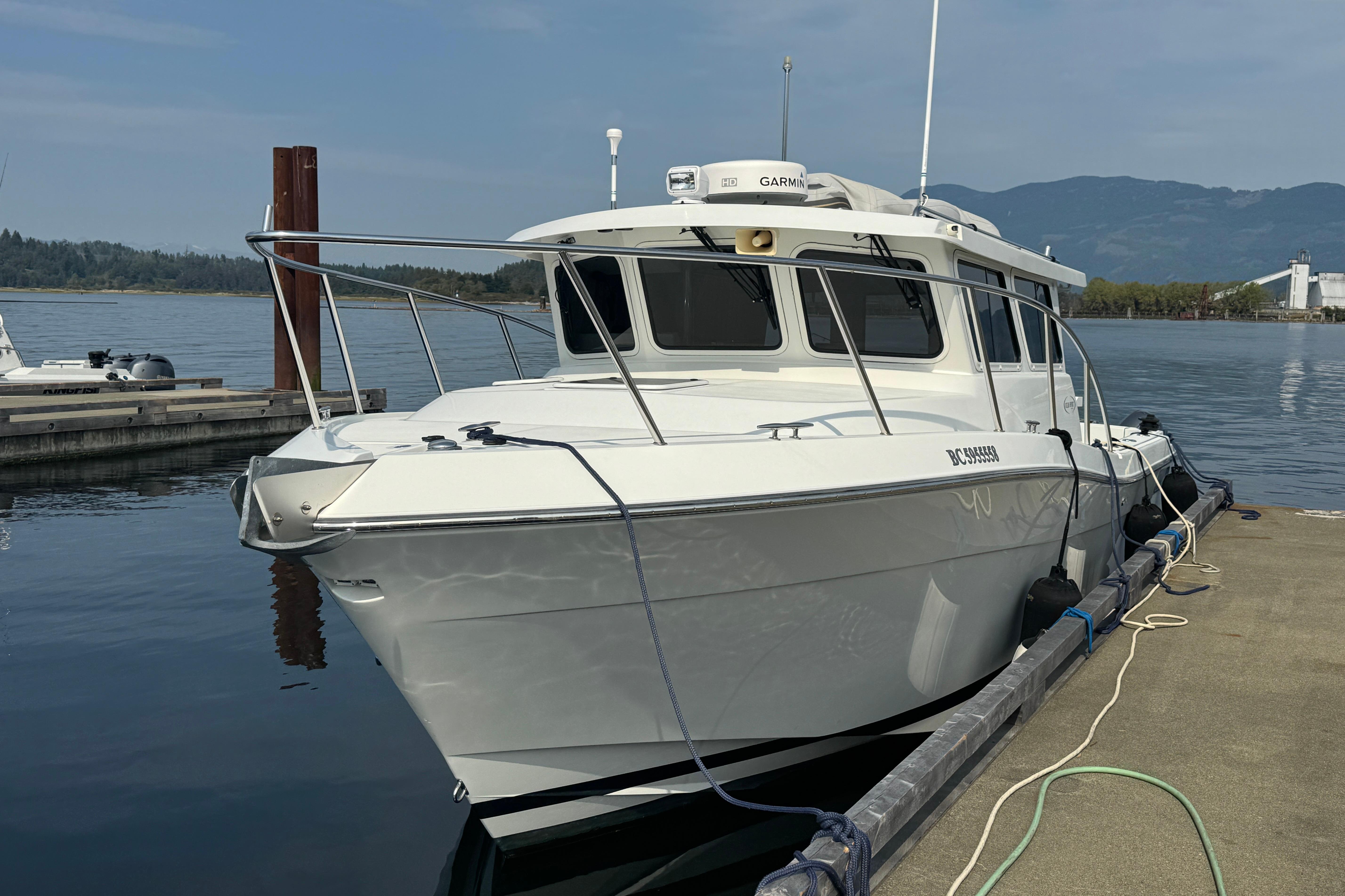 Ocean Sport Roamer 2017 Ocean Sport Roamer boat docked at marina with scenic mountain backdrop.