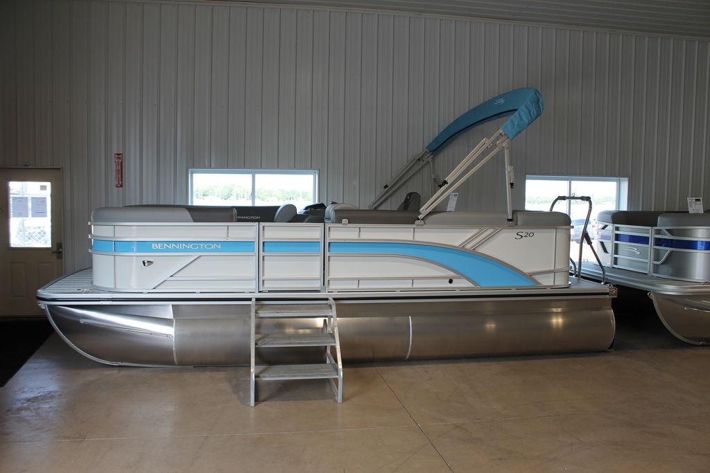 Bennington S L-Bench 20 SL 2026 Bennington S L-Bench 20 SL pontoon boat in showroom, featuring sleek design and blue accents.