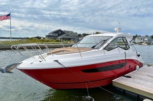 Sea Ray Sundancer 350 Coupe 2017 Sea Ray Sundancer 350 Coupe docked, featuring sleek red and white design.