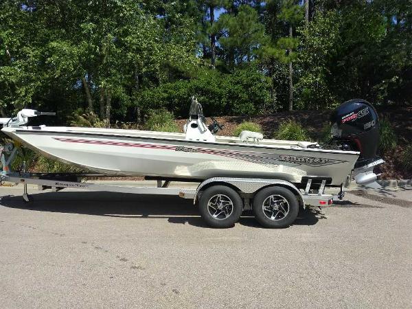 Ranger RB200 2024 Ranger RB200 boat on trailer, parked outdoors, surrounded by trees.