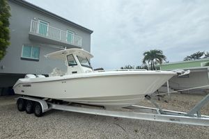 Everglades 295 Center Console 2016 Everglades 295 Center Console boat on trailer, parked near modern building.