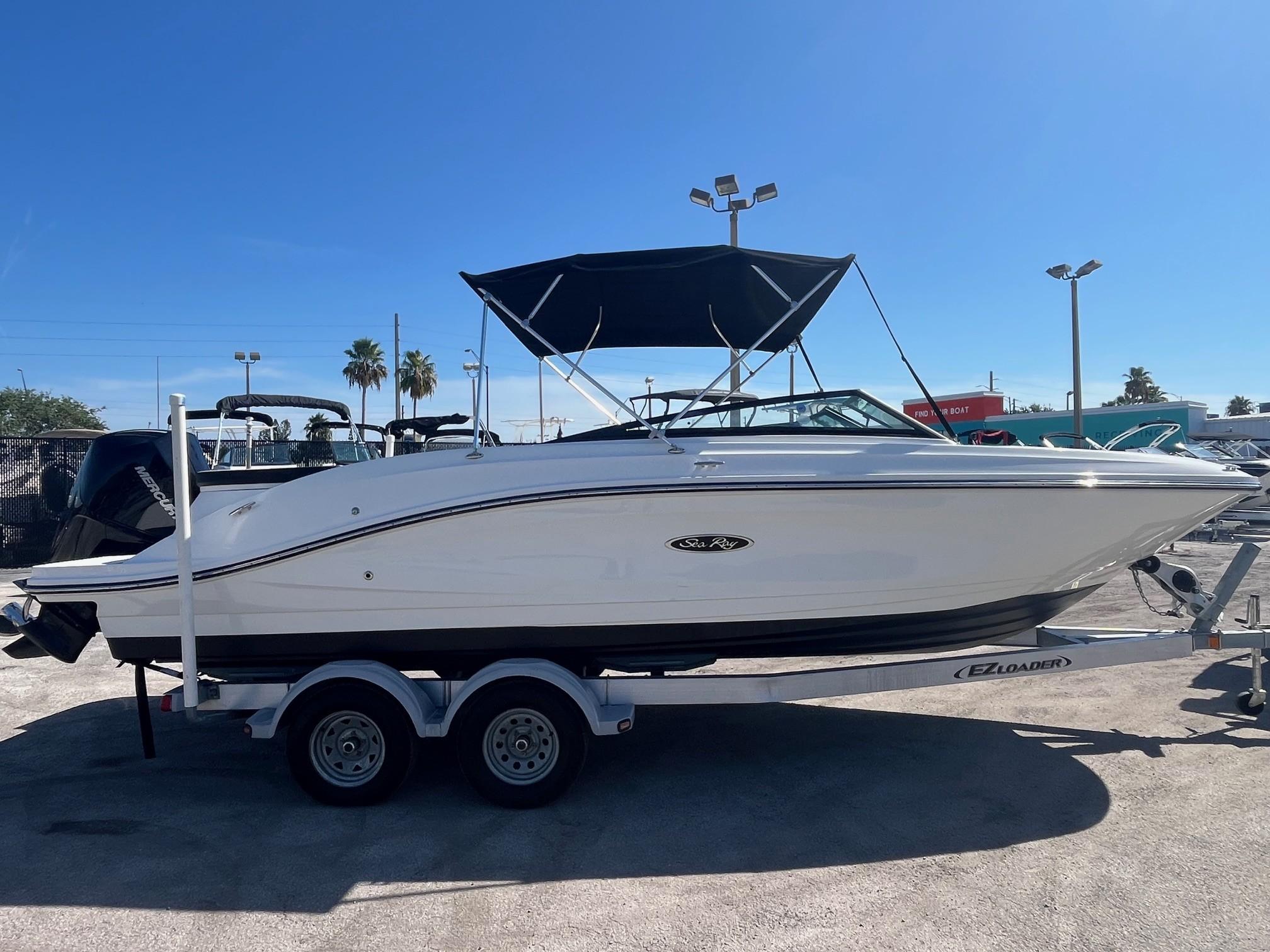 Sea Ray SPX 230 Outboard 2024 Sea Ray SPX 230 Outboard boat on trailer, sunny day, palm trees in background.