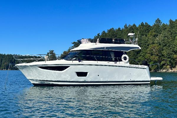 Jeanneau Velasco 37F 2019 Jeanneau Velasco 37F yacht on serene water with forested background.