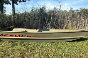 Tracker Grizzly 12 Jon 2026 Tracker Grizzly 12 Jon boat on grass, surrounded by tall reeds and trees.