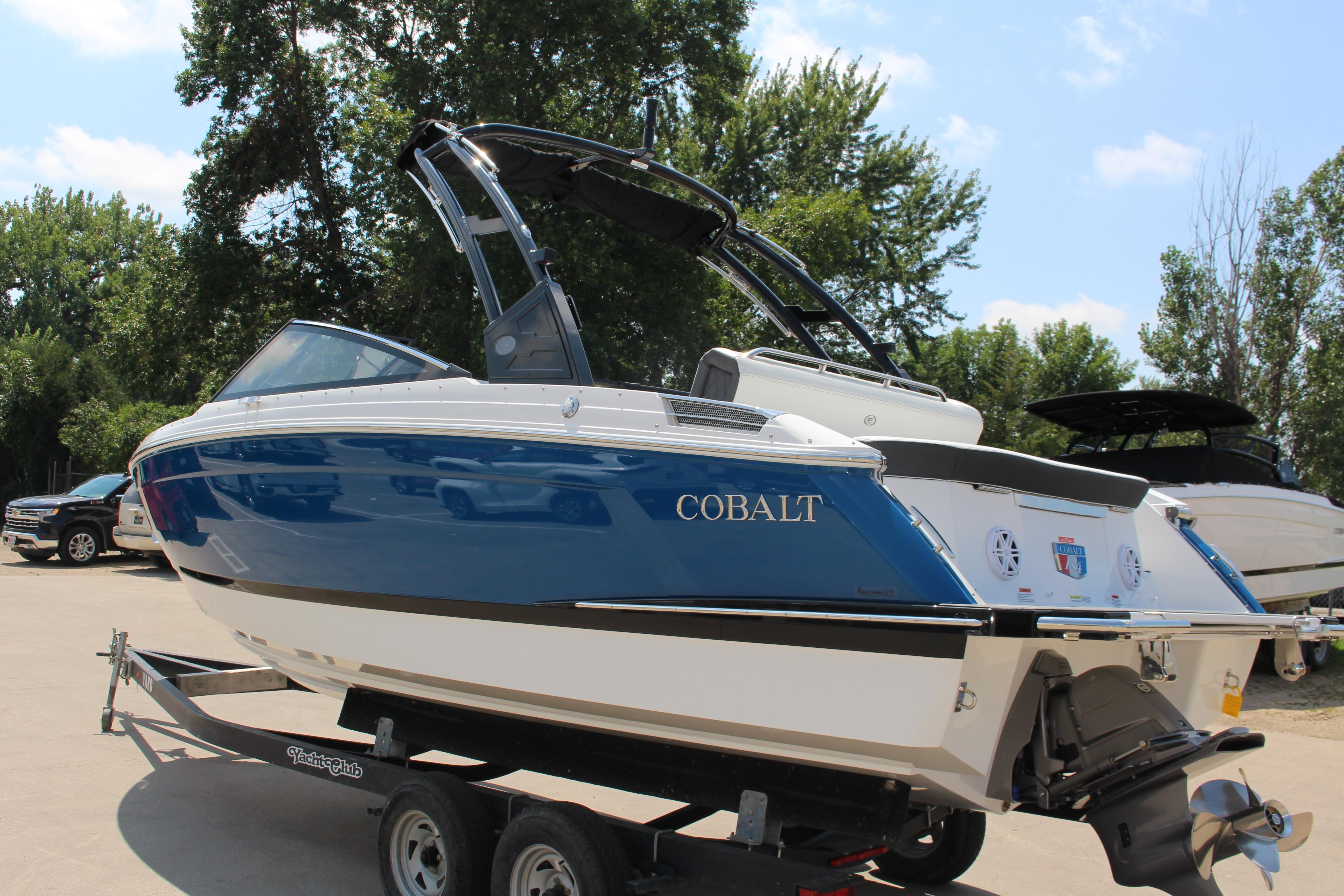 Cobalt R4 2025 Cobalt R4 boat on trailer, blue and white design, parked outdoors.