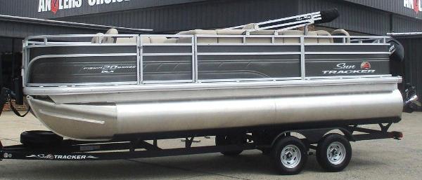 Sun Tracker Fishin' Barge 20 DLX 2025 Sun Tracker FISHIN' BARGE® 20 DLX pontoon boat on trailer, parked outside.