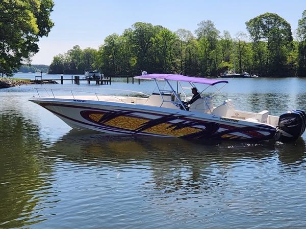 Fountain 38 Center Console 2003 Fountain 38 Center Console boat with vibrant graphics on a calm lake.