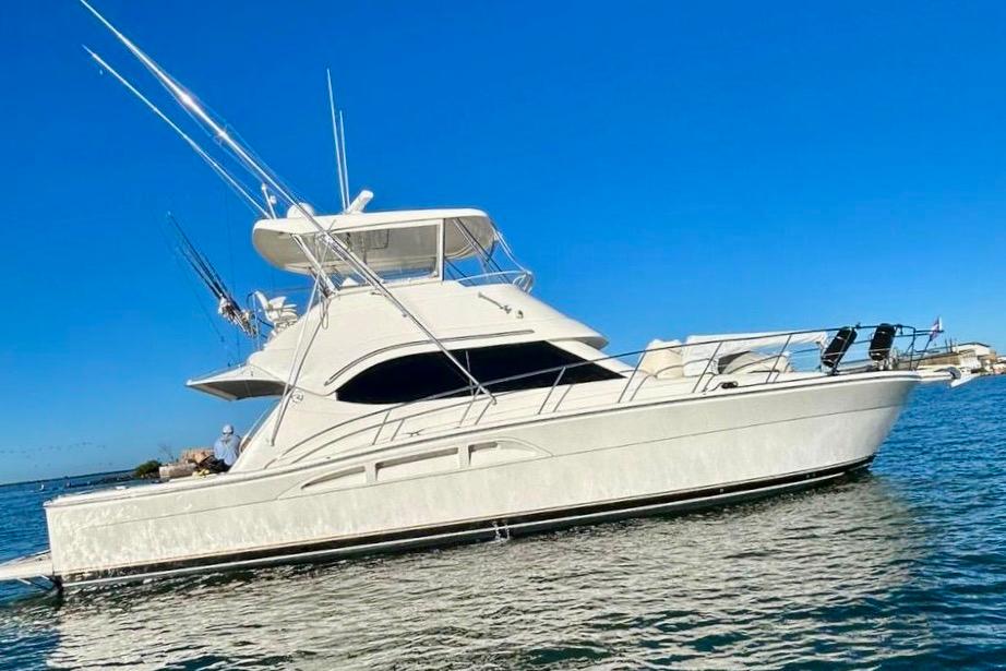 Riviera Convertible Luxury 2005 Riviera Convertible yacht on calm blue waters under clear sky.