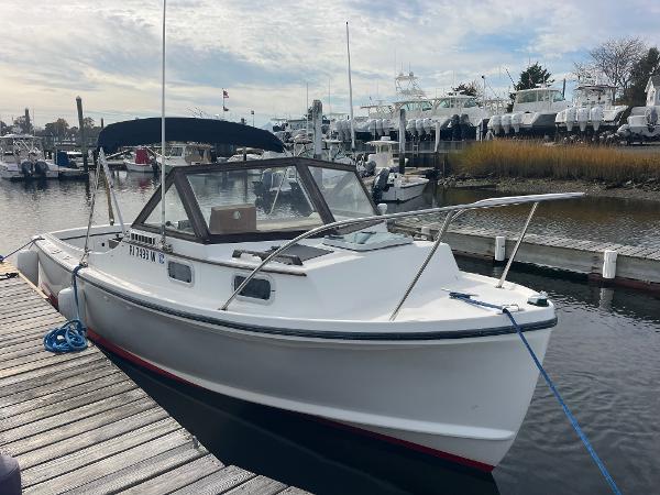 Tripp Angler 22 1993 Tripp Angler 22 boat docked at marina under cloudy sky.