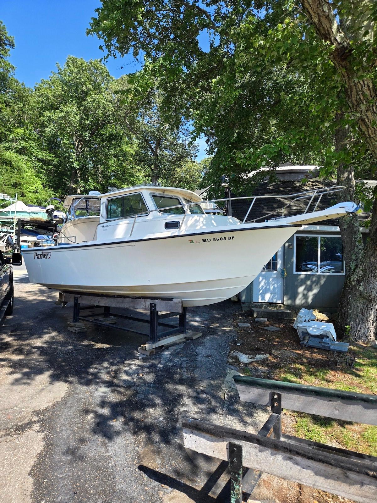 Parker 2120 Sport Cabin 2003 Parker 2120 Sport Cabin boat on a stand, surrounded by trees.