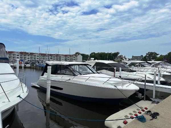 Regal 36 Grande Coupe 2025 Regal 36 Grande Coupe yacht docked in a marina under a cloudy sky.