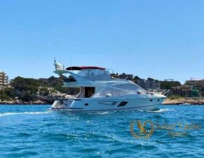 Galeon 530 Fly Galeon 530 Fly yacht cruising near rocky coastline, clear blue water, sunny day, 2009 model.