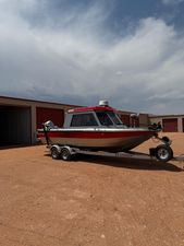 Jetcraft 2225 2010 Jetcraft 2225 boat on trailer, parked outside storage units under cloudy sky.