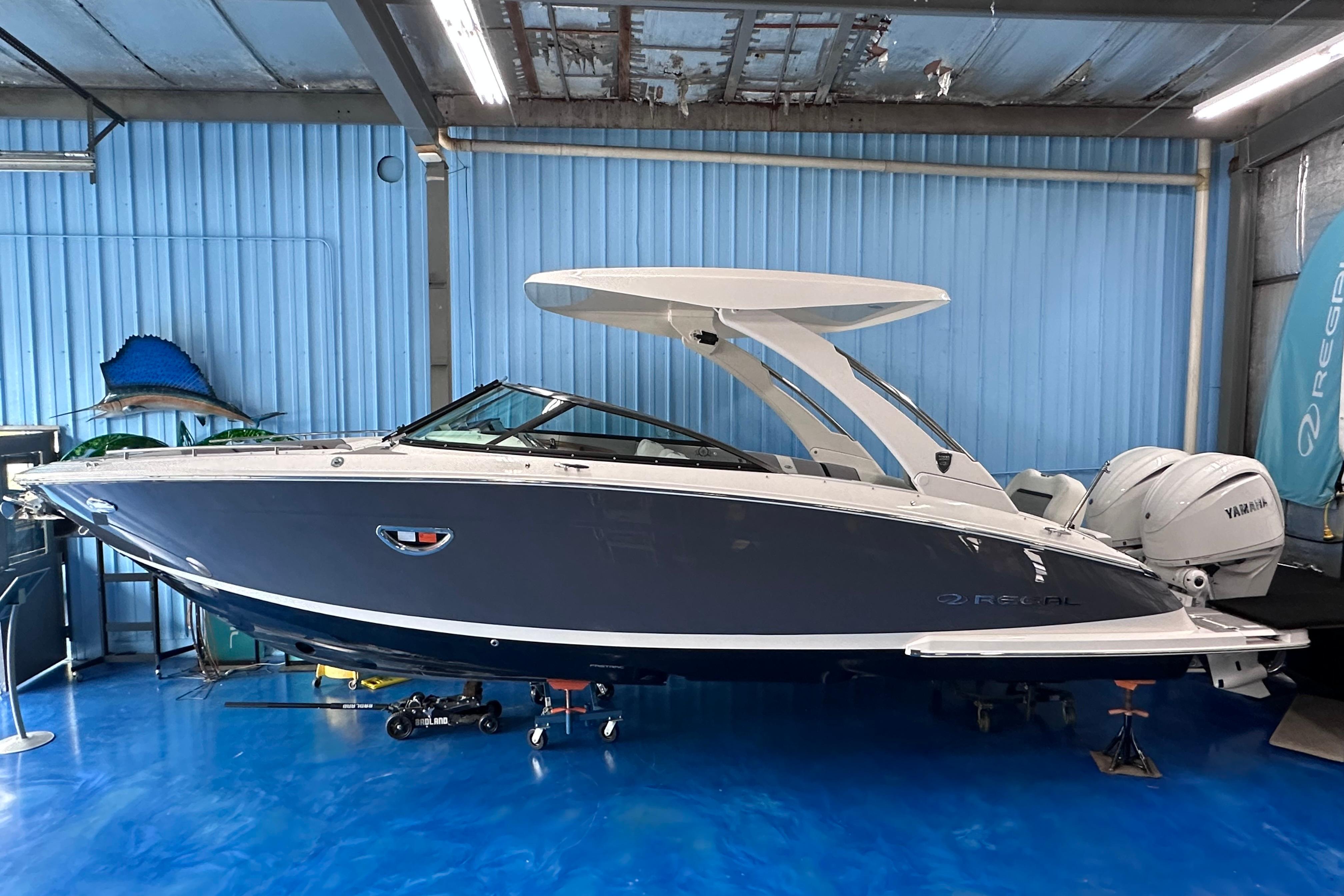 Regal LX9 2026 Regal LX9 boat in showroom, sleek design with blue hull and white accents.
