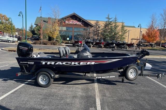 Tracker Super Guide V-16 SC 2026 Tracker Super Guide V-16 SC boat in parking lot, with building and trees in background.