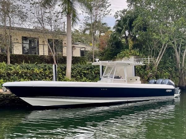 Intrepid 370 Open REPOWERED 2010 Intrepid 370 Open REPOWERED boat docked by lush greenery.